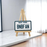 Personalized mini license plate displayed on wooden tripod stand for product presentation